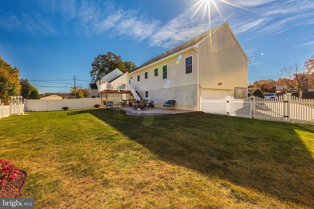 rear view of property featuring a garage, a patio, and a lawn