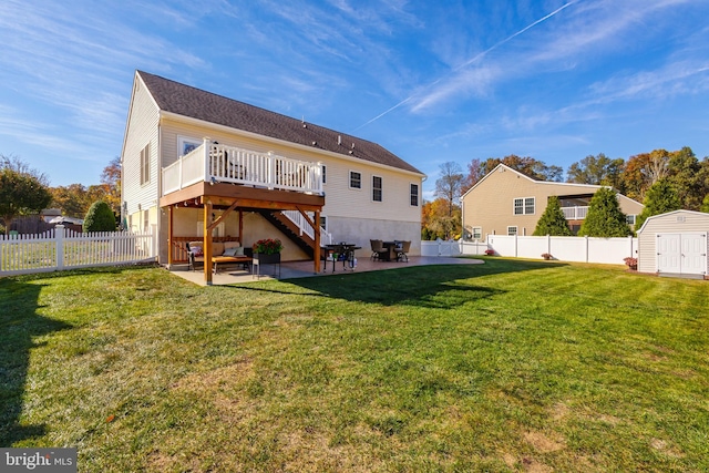 back of property featuring a shed, a yard, a deck, and a patio area