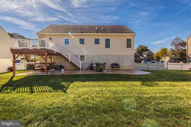 rear view of property featuring a yard, a patio, and a deck