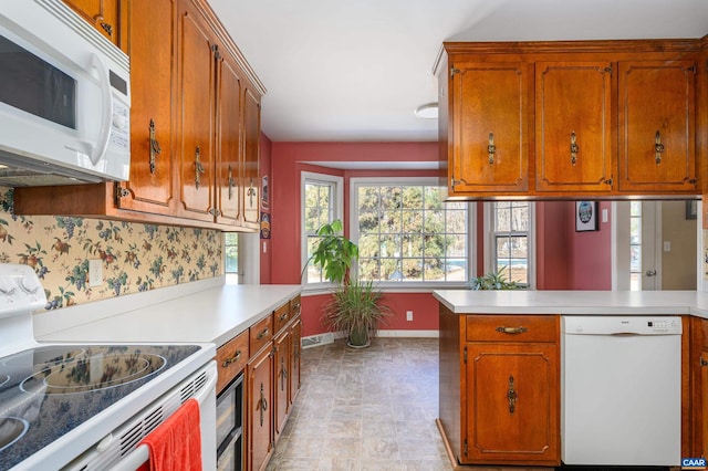 kitchen featuring white appliances and kitchen peninsula