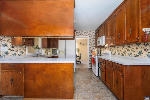 kitchen featuring sink, white appliances, and kitchen peninsula