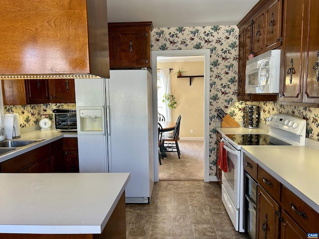 kitchen with white appliances, sink, and dark colored carpet