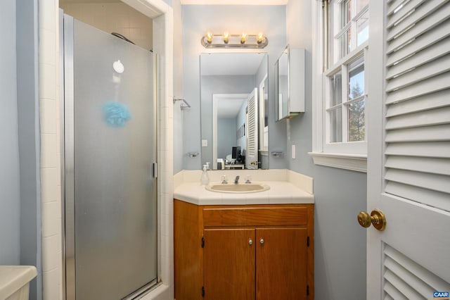 bathroom featuring vanity and a shower with door