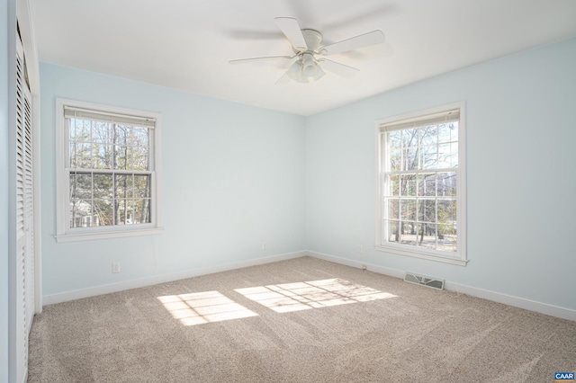 empty room featuring ceiling fan and light colored carpet