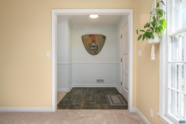 doorway with a wealth of natural light and dark colored carpet