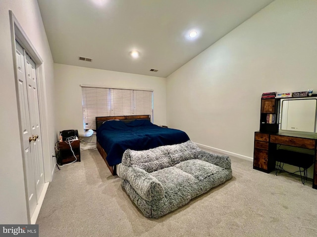 carpeted bedroom featuring vaulted ceiling and a closet