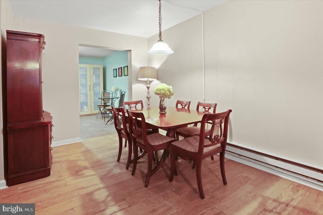 dining space with light hardwood / wood-style flooring and baseboard heating