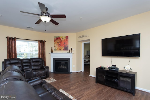 living room featuring ceiling fan and dark hardwood / wood-style flooring