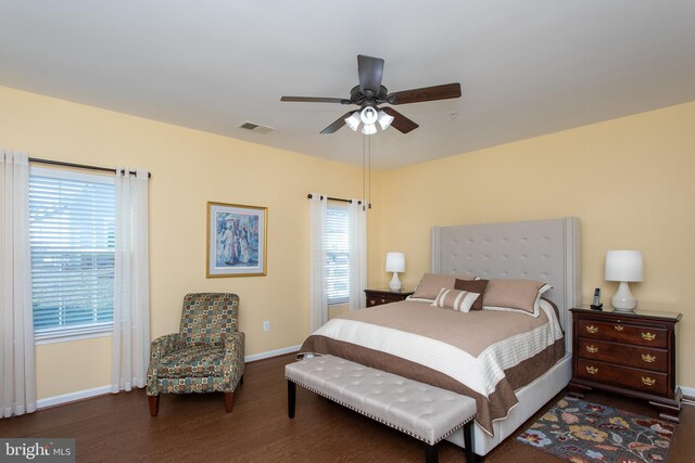 bedroom featuring multiple windows, dark hardwood / wood-style flooring, and ceiling fan