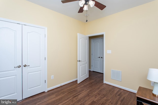 unfurnished bedroom featuring ceiling fan, dark hardwood / wood-style flooring, and a closet