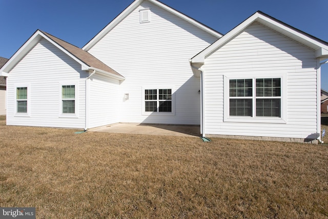 rear view of property featuring a lawn and a patio