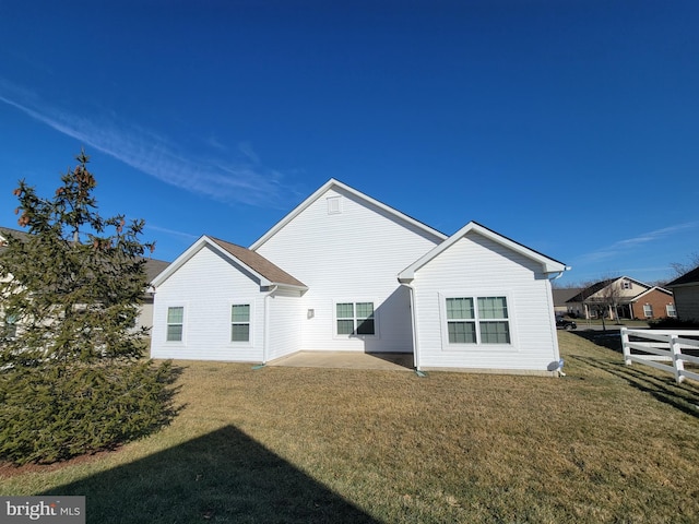 rear view of property with a yard and a patio area