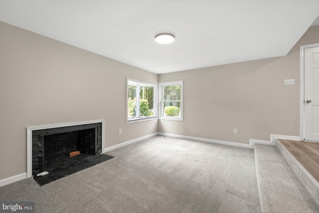 unfurnished living room with carpet floors and a fireplace