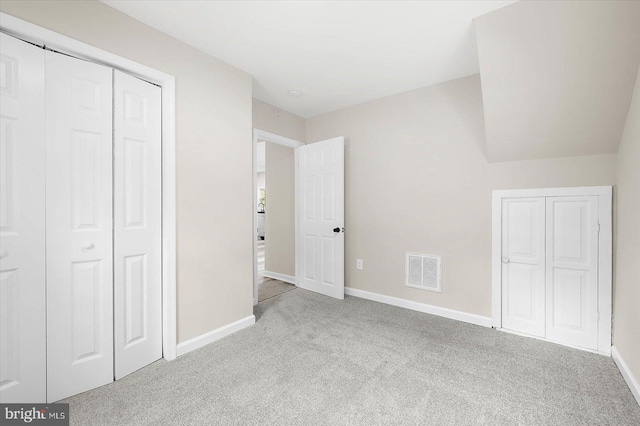 unfurnished bedroom with light carpet and a closet