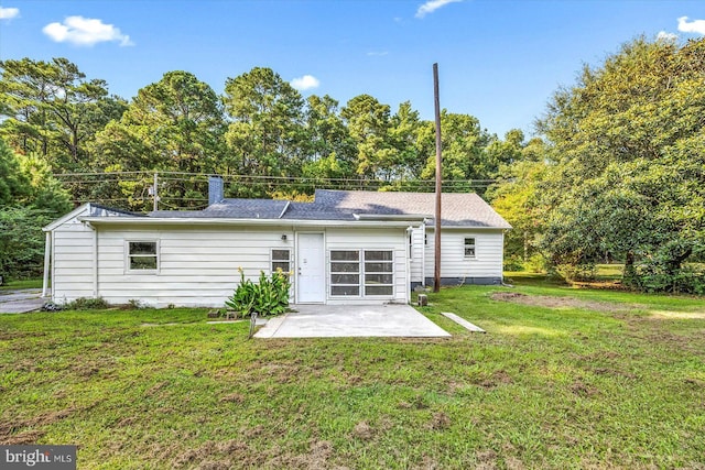 rear view of house with a yard and a patio area