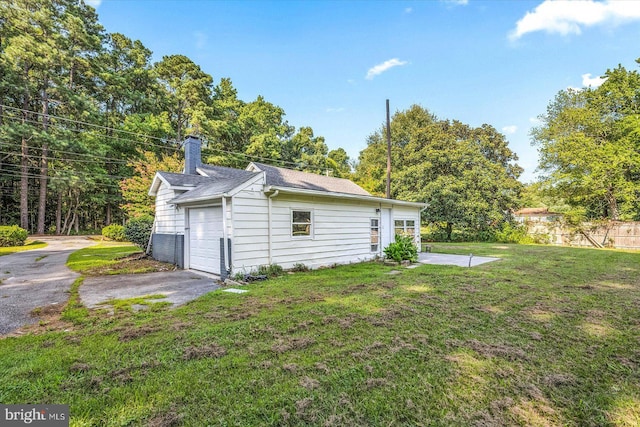 exterior space featuring a garage and a lawn