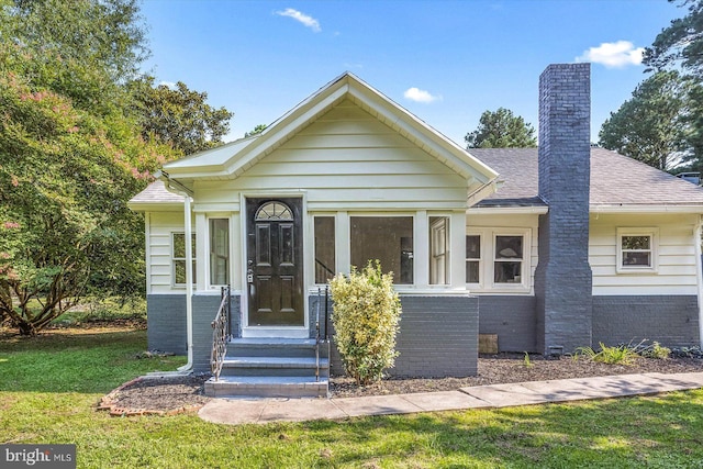 bungalow-style home with a front yard