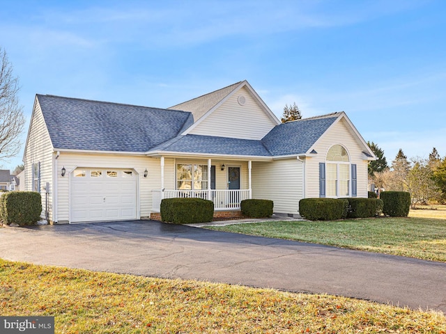 view of front property with a garage, a front lawn, and a porch