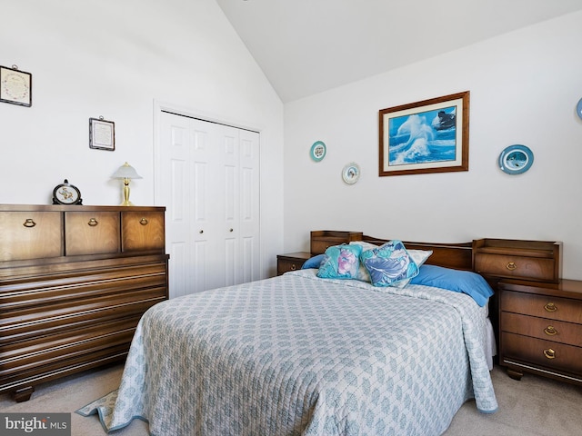 carpeted bedroom with vaulted ceiling and a closet