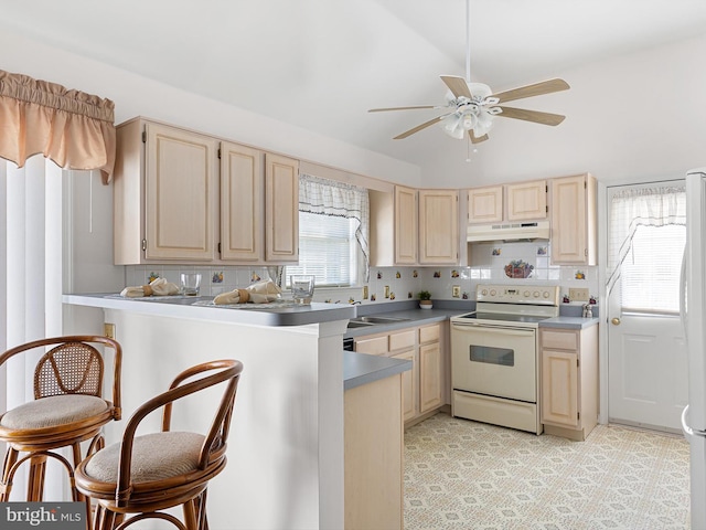 kitchen with light brown cabinetry, backsplash, ceiling fan, kitchen peninsula, and white appliances