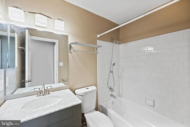 full bathroom with vanity, tiled shower / bath, and toilet