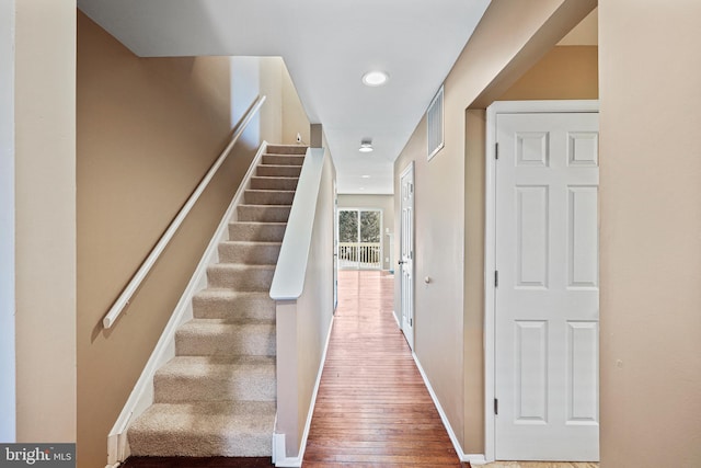 staircase with hardwood / wood-style floors