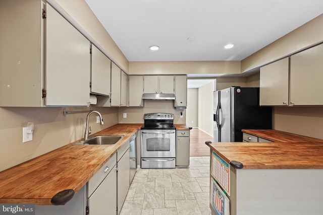 kitchen featuring appliances with stainless steel finishes, butcher block counters, and sink