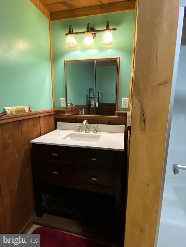 bathroom featuring vanity and wooden walls