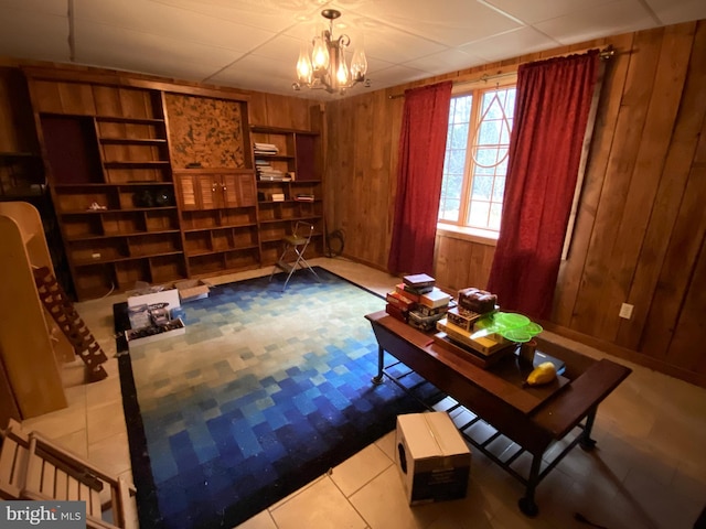 sitting room featuring a chandelier, tile patterned flooring, built in features, and wood walls