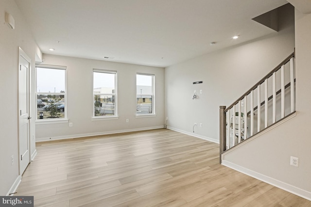 interior space with light wood finished floors, baseboards, visible vents, stairway, and recessed lighting