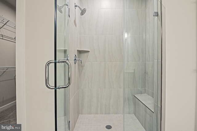 full bathroom featuring a stall shower and a walk in closet