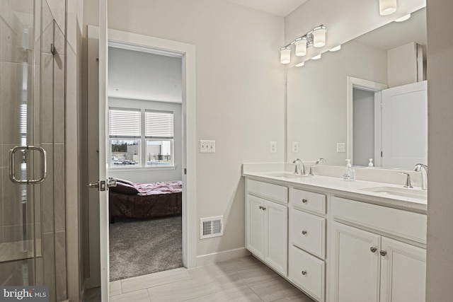 ensuite bathroom featuring double vanity, a sink, visible vents, and connected bathroom