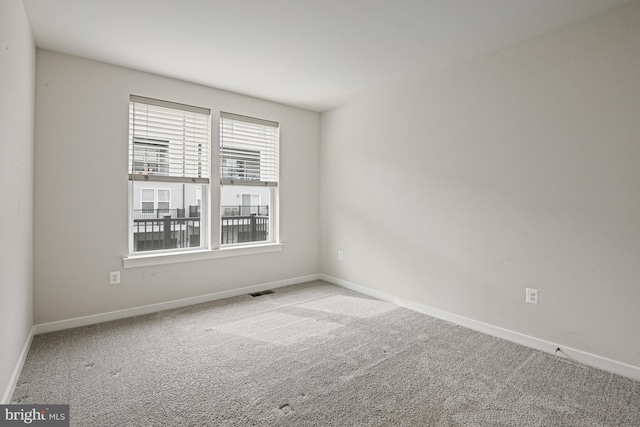 unfurnished room with visible vents, baseboards, and light colored carpet