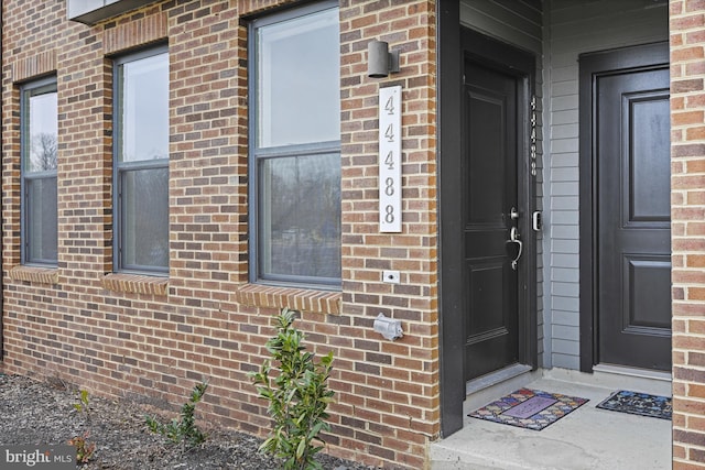 view of exterior entry featuring brick siding