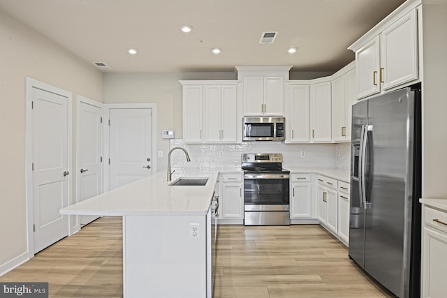 kitchen with visible vents, appliances with stainless steel finishes, light countertops, white cabinetry, and a sink