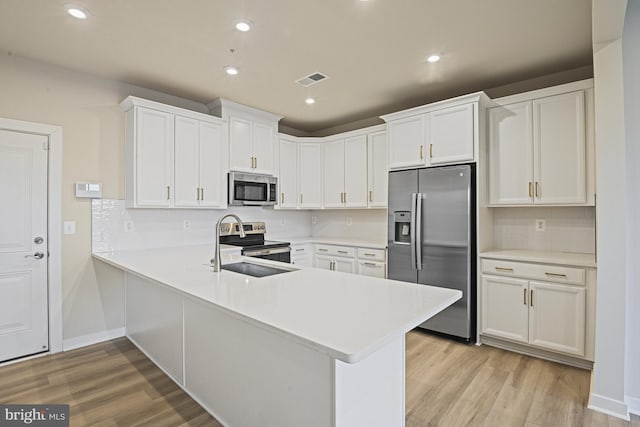 kitchen featuring stainless steel appliances, light countertops, and white cabinetry