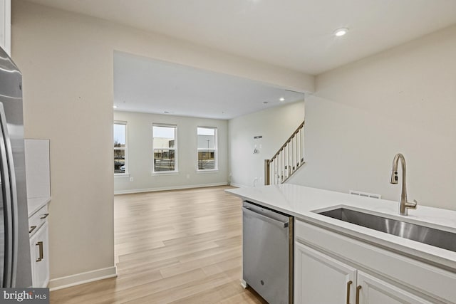 kitchen with appliances with stainless steel finishes, open floor plan, light countertops, and white cabinetry