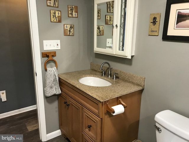 bathroom featuring hardwood / wood-style flooring, vanity, and toilet