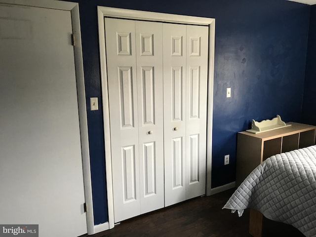 bedroom with dark wood-type flooring and a closet