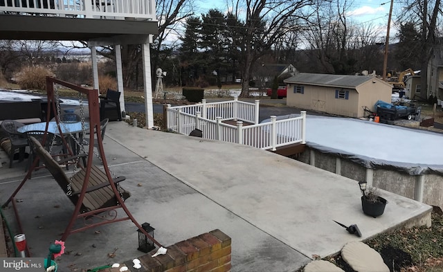 view of patio / terrace with a wooden deck and an outdoor structure