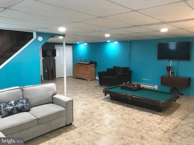 playroom featuring a paneled ceiling and a baseboard heating unit