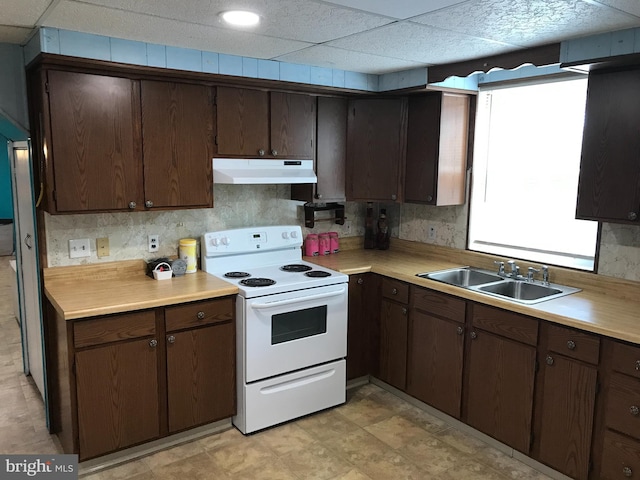 kitchen with dark brown cabinetry, sink, backsplash, and white range with electric stovetop