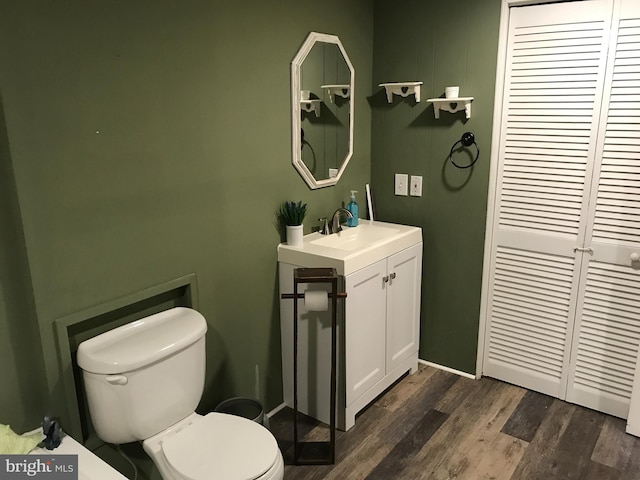 bathroom with vanity, toilet, and hardwood / wood-style floors