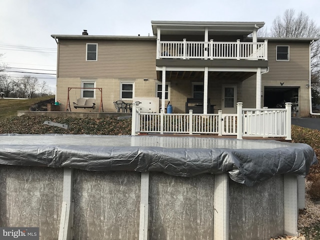 back of house featuring a balcony and a garage