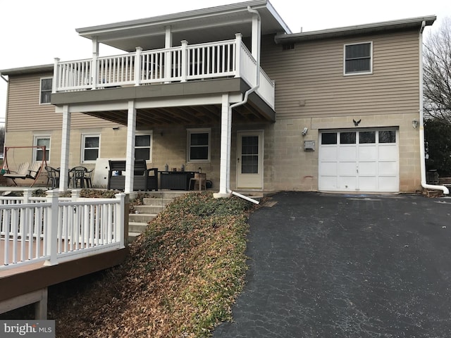 back of house with a garage and a balcony