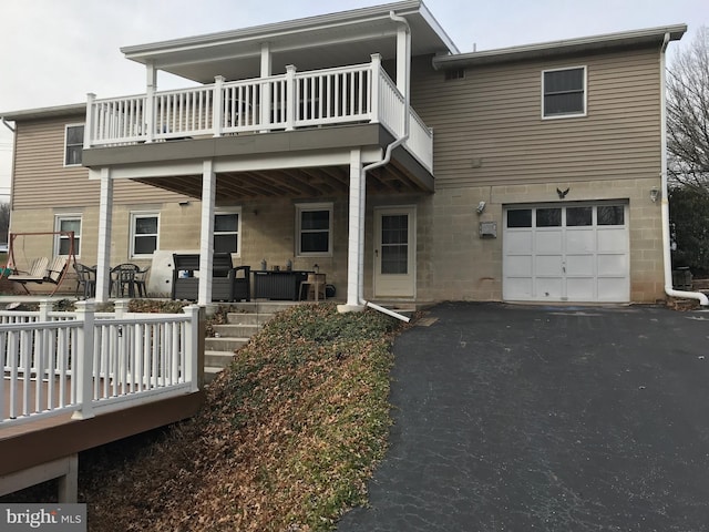 back of house featuring a garage and a balcony