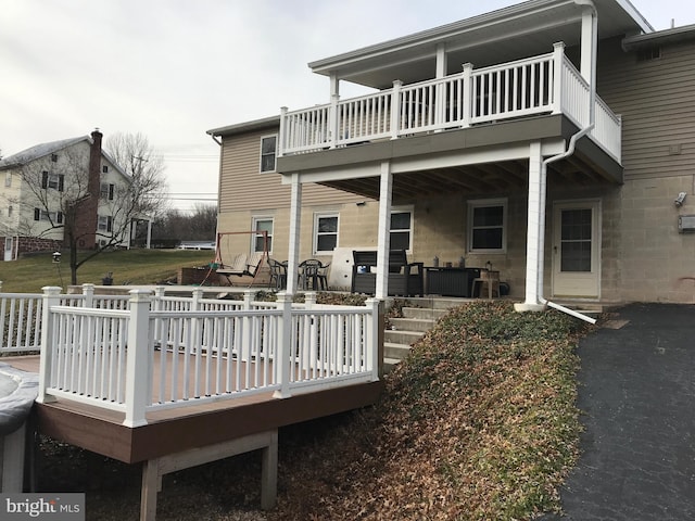 rear view of house with a wooden deck and a balcony