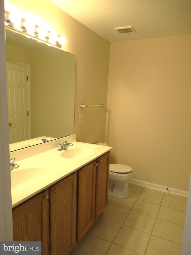 bathroom featuring tile patterned flooring, vanity, and toilet