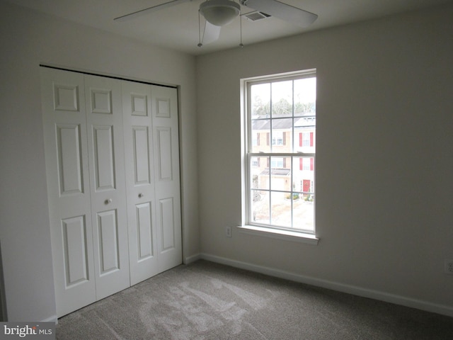 unfurnished bedroom with light colored carpet, ceiling fan, and a closet