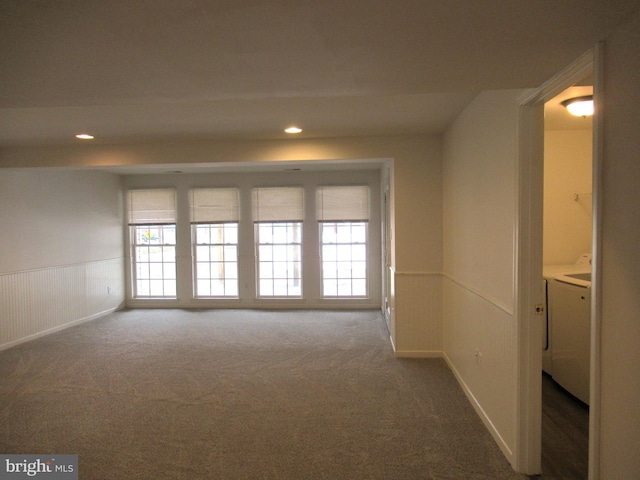 carpeted empty room featuring washing machine and dryer and plenty of natural light